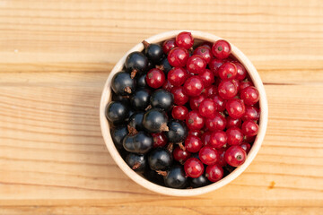 black and red currant berries in a clay cup. mix currant berries. natural product