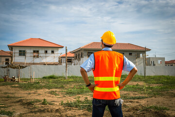 Construction worker, male, Asian, wearing masks and helmets Standing and looking at the construction work that is starting the project