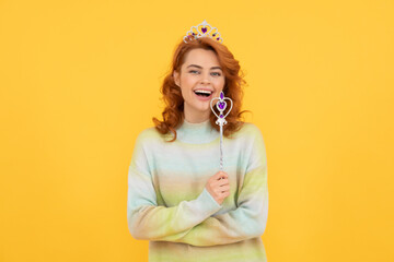 happy redhead woman in queen crown with magic wand, dreams come true