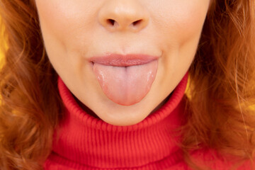 Sticking her tongue out. Woman cropped view stick clean tongue out of mouth