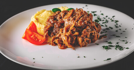 Fried liver with onion and mashed potatoes on white plate