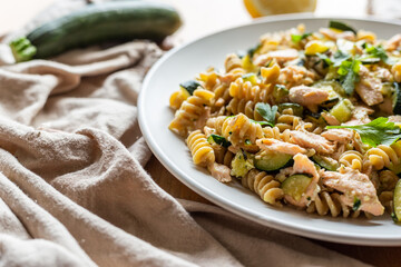Fusilli pasta with zucchini and salmon fish.