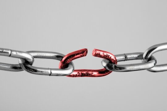 Silver chain with red broken link, concept of freedom.