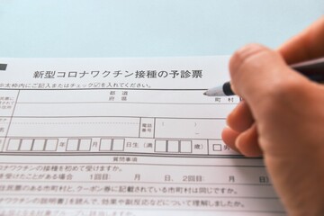 Obraz premium 新型コロナワクチン接種の予診票に記入