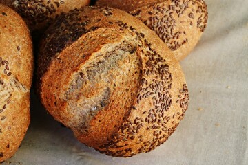 Pan de trigo de aspecto crujiente expuesto para su venta. Pan orgánico y tradicional con semillas en un puesto de venta callejero en la feria del campo de Bustarviejo, Madrid, España.
