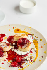 
Cheesecakes with berry and mango sauce, chocolate, cherry
