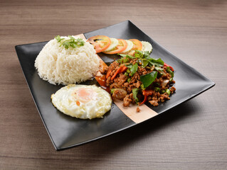stir fried minced chicken meat in spicy chilli  sauce with white rice and fried egg on wood background asian halal set lunch menu
