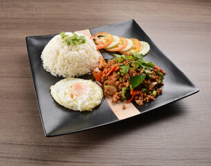 stir fried minced chicken meat in spicy chilli  sauce with white rice and fried egg on wood background asian halal set lunch menu