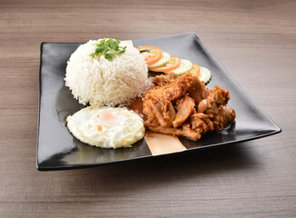 stir fried chicken meat in garlic soy sauce with white rice and fried egg on wood background asian halal set lunch menu
