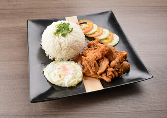 stir fried chicken meat in garlic soy sauce with white rice and fried egg on wood background asian halal set lunch menu