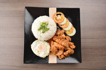 stir fried chicken meat in garlic soy sauce with white rice and fried egg on wood background asian halal set lunch menu