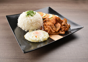 stir fried chicken meat in garlic soy sauce with white rice and fried egg on wood background asian halal set lunch menu