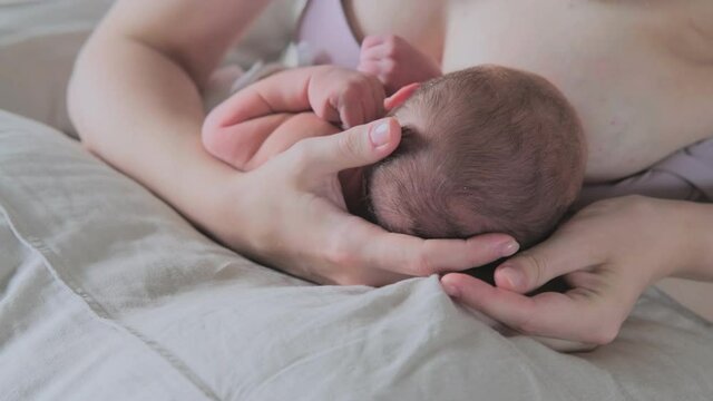 Mom feeds a newborn baby with milk from the breast