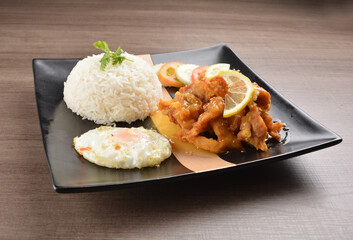 stir fried chicken meat in lemon sour sauce with white rice and fried egg on wood background asian halal set lunch menu