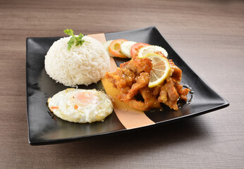 stir fried chicken meat in lemon sour sauce with white rice and fried egg on wood background asian halal set lunch menu