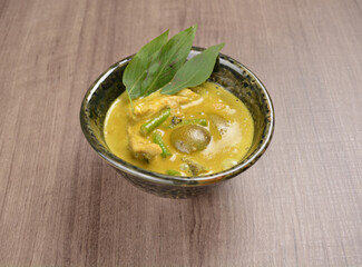 Thai green curry spicy soup with chicken meat and vegetable in bowl on wood background asian halal set lunch menu