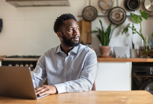 African American Businessman Working From Home Looking Out Of Window