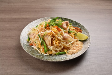 wok fried noodle phad Thai with chicken meat on wood background asian halal set lunch menu