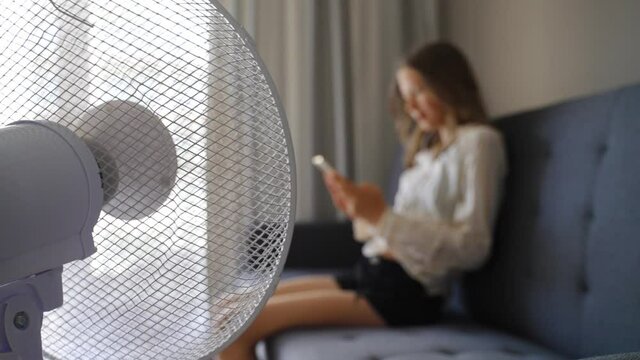 Teenager with the phone in front of cooling fan.