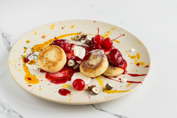 Cheesecakes with berry and mango sauce, chocolate, cherry