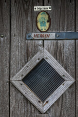 men sign on toilet of alpine cabin