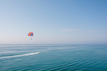Persona en paracaídas remolcada por una lancha rápida
