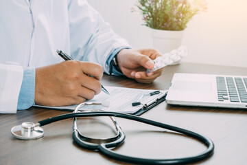 Medicine in doctor hands and heart rate checking report paper's patient diagnosing of doctor on...
