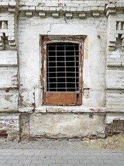 Old window with iron bars in a stone house