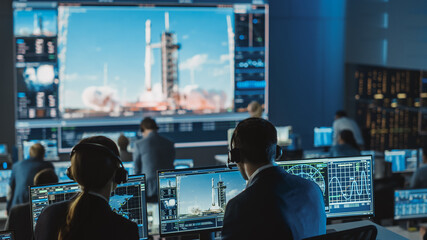 Group of People in Mission Control Center Witness Successful Space Rocket Launch. Flight Control Employees Sit in Front Computer Displays and Monitor the Crewed Mission. - Powered by Adobe