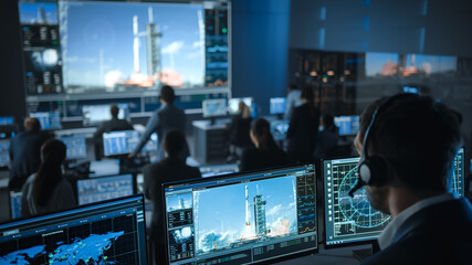 Space Flight Dispatcher in Mission Control Center Witness Successful Space Rocket Launch. Flight Control Employees Sit in Front Computer Displays and Monitor the Crewed Mission.