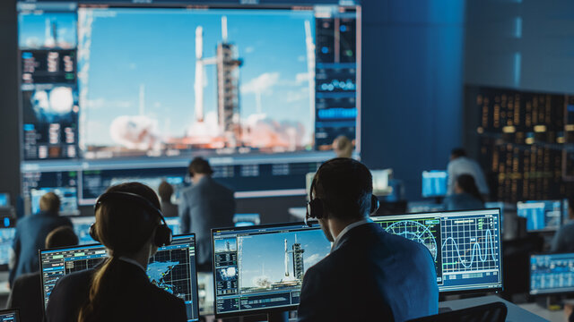 Group of People in Mission Control Center Witness Successful Space Rocket Launch. Flight Control Employees Sit in Front Computer Displays and Monitor the Crewed Mission.