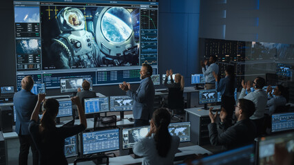 Group of People in Mission Control Center Establish Successful Video Connection on a Big Screen...