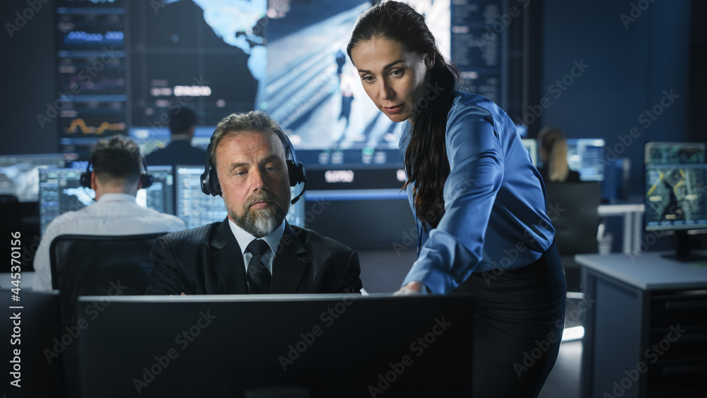 Aufkleber male and female government officers discuss working matters next to a computer and big digital scree