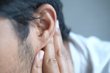 Fototapeta premium young man having ear pain touching his painful ear ,