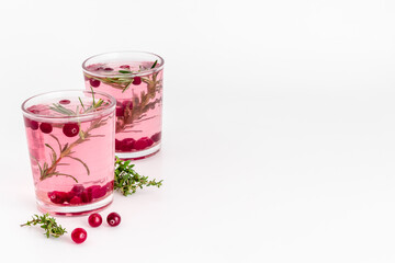 Glasses of cranberry lemonade and red oranges with rosemary