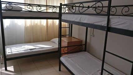 metal bunk beds and a bedside table in the hostel room