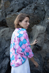 Natural beauty of as young lady Posing in the shore of the coast side in a tourist location with rocks background