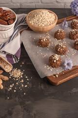 Obraz na płótnie Canvas Healthy organic energy granola balls with oat flakes, peanuts, dates, cacao, banana, chocolate and honey - vegan vegetarian raw snack or meal