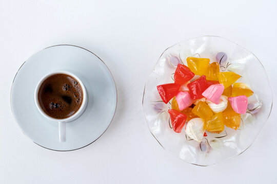 Sweet candies or akide sugars and cup of Turkish coffee, the traditional beverage of the Turkey, isolated on white background, with copy space for text, Top view
