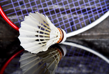 Badminton shuttelcock on glass reflection with racket as a background