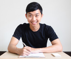 Asian man happy smile sit at desk with check list and mobile phone interview concept