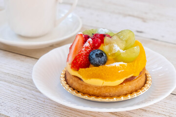 白いお皿の上のフルーツタルトとコーヒーカップ