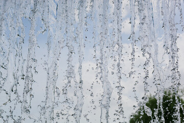 inside view of the falling water of the waterfall against the blue sky. water in motion