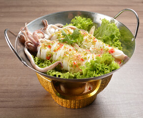 steamed octopus with spicy chilli sauce in hot pot on wood table asian halal menu