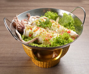 steamed octopus with spicy chilli sauce in hot pot on wood table asian halal menu