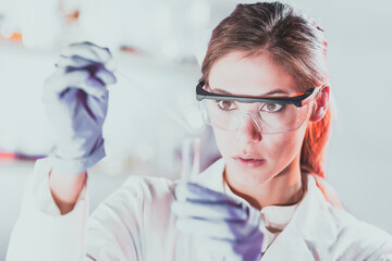 Young scientist pipetting in life science laboratory.