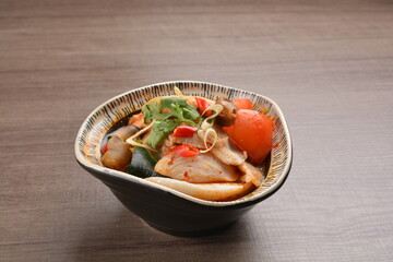 Thai tomyum seafood meat hot soup with spicy chilli sauce on wood table asian halal menu