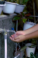 Washing hands with running water in the faucet while rubbing to keep them clean and avoid dangerous...