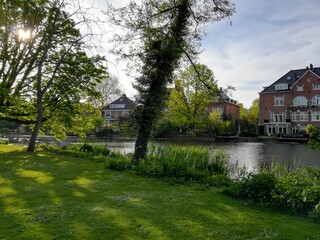 Fototapeta na wymiar Parc et maisons traditionnelles à Amsterdam au bord du canal