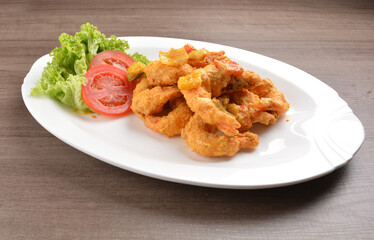 wok fried tiger prawn in salted egg yolk curry paste sauce on wood table asian halal menu